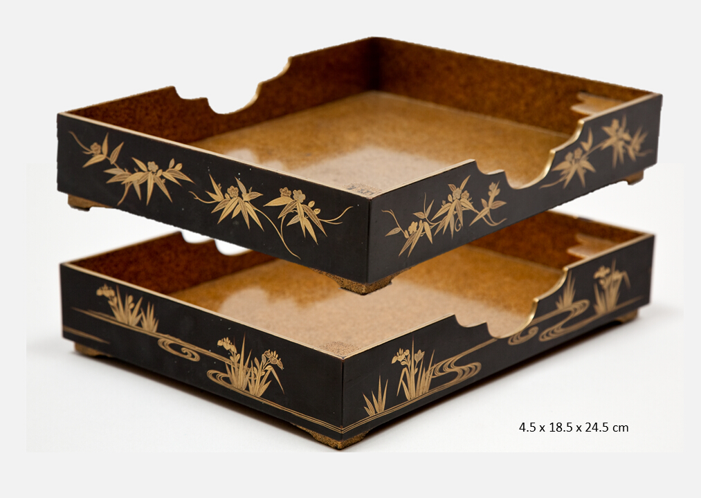 Two rectangular, low, open trays with scalloped cutouts on the long sides, one decorated on the exterior sides with bamboo grass, the other with lilies in a waterscape. The insides have sprinkled gold flakes so called (nashiji) resembling pear-skin. The trays are fitted with feet and stackable on each other.