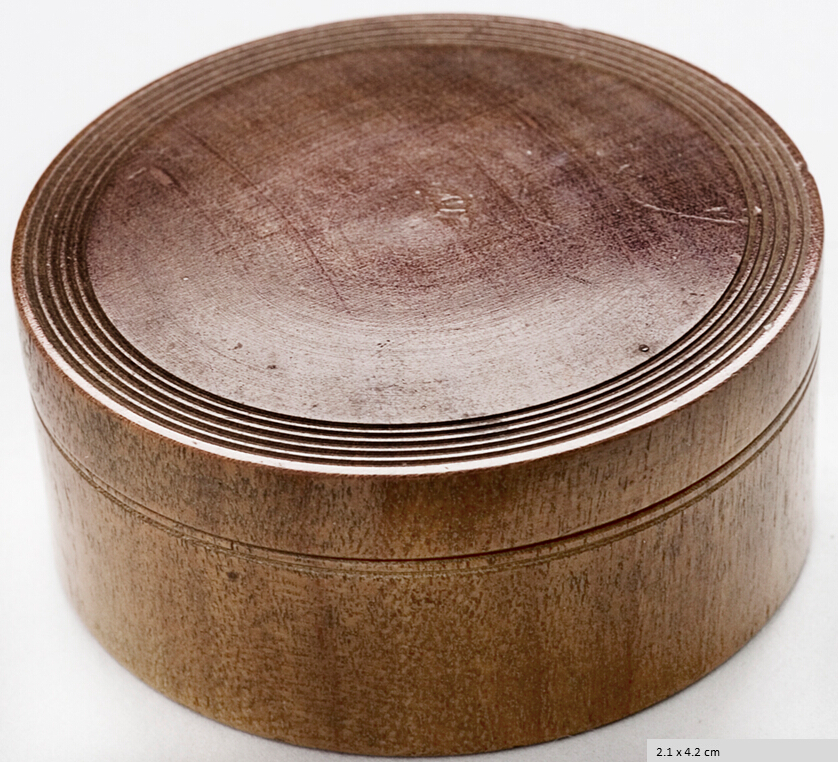Cylindrical etui with lid turned from a single piece of wood, cut as hikimono yokobiki, i.e. with the grain parallel to the bottom and cover. Five concentric grooves on the top circumference the cover.