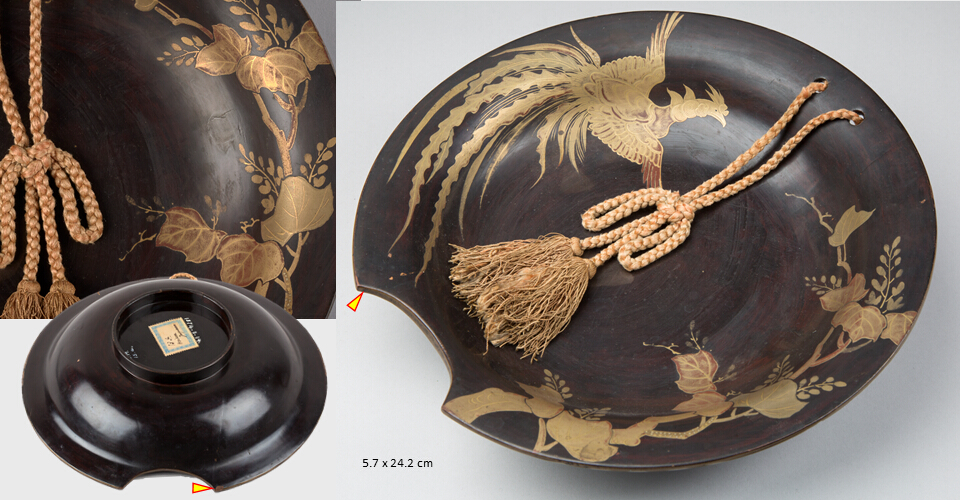 Shallow, round shaving basin with a semicircular cutout on its rim and a plaited cord with tassel on the opposite side. Decorated with gold hira-makie on red (bengara) ground depicting a flying phoenix and maple foliage. The sample position for analyses is marked with a yellow triangle.